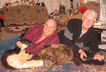 Two men lying on a bearskin rug.